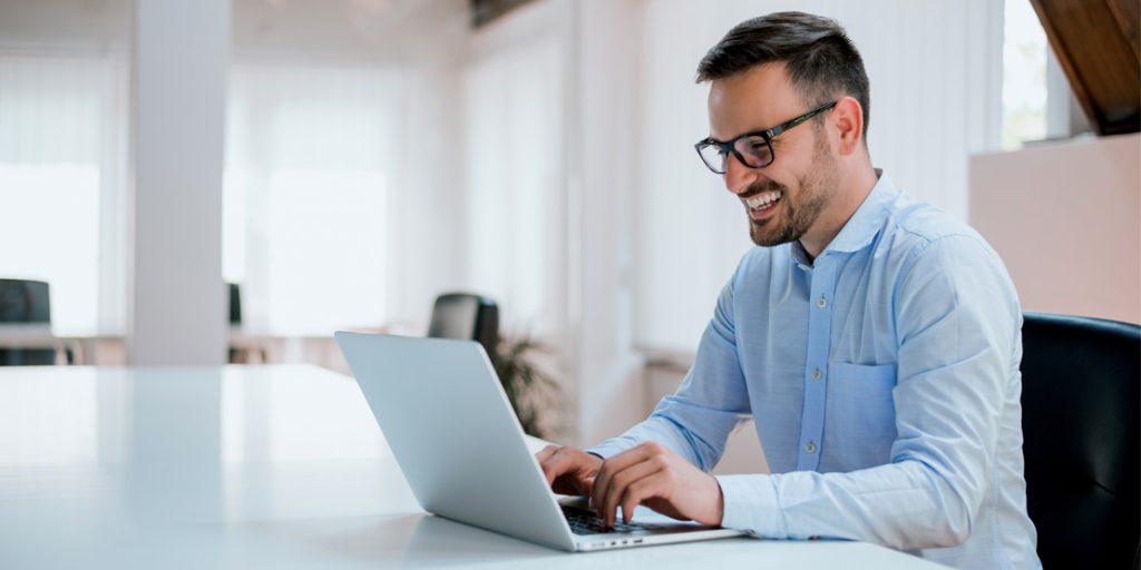 Portrait of young man sitting at his desk in the office