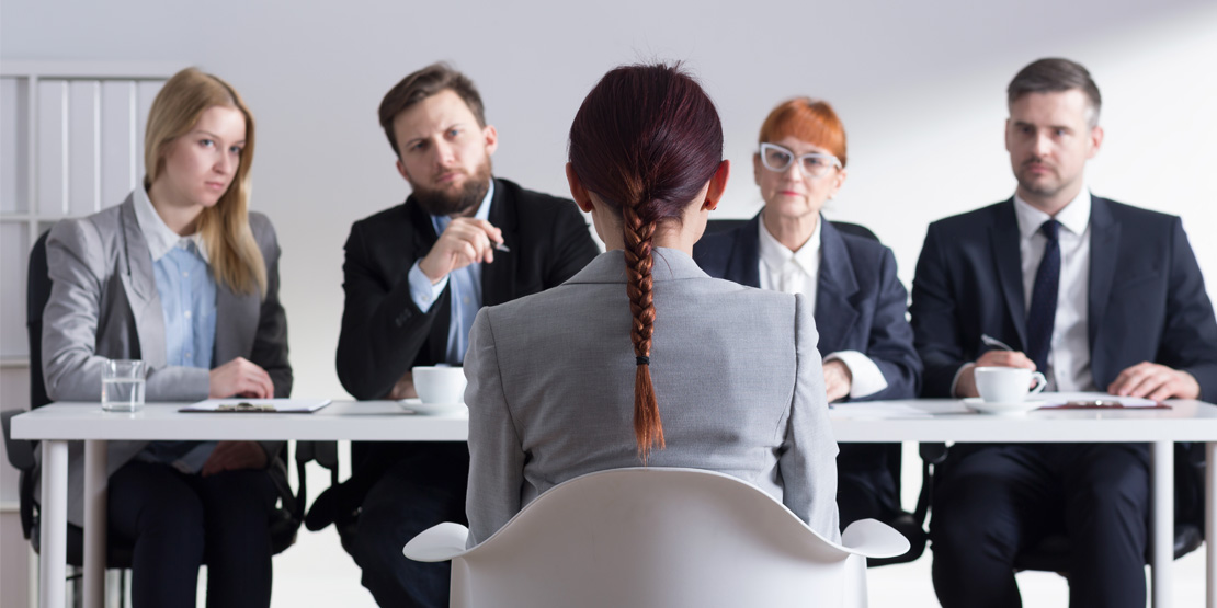 Woman during job interview and four elegant members of management